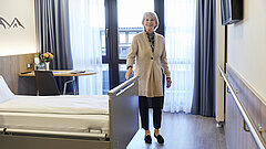 Eine Medical Park Patientin steht neben ihrem Klinikbett der geriatrischen Reha.